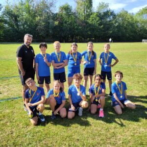 Photo of the Paddock Wood Primary Academy Rounders Team posing for the camera together outdoors.